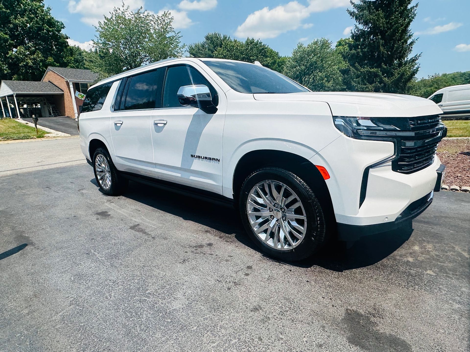 White Chevrolet SUV parked on a driveway on a sunny day.