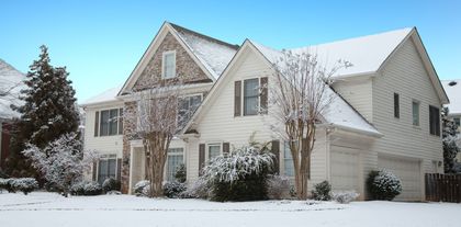 Une grande maison blanche est recouverte de neige