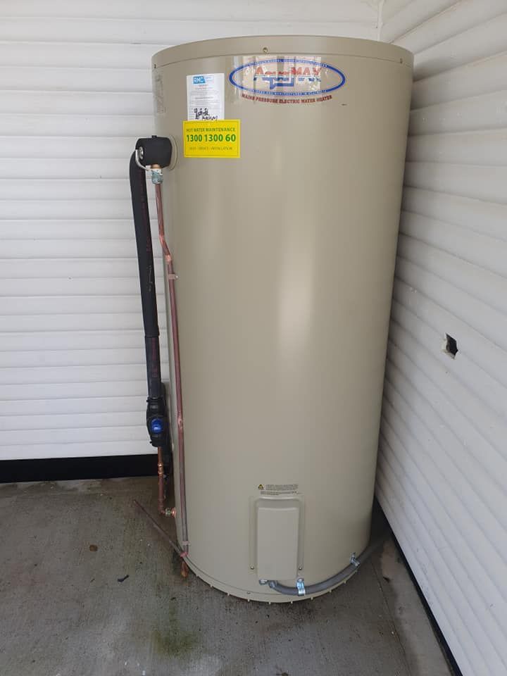 A Beige Cylindrical Water Heater Stands in a Corner — Hot Water Maintenance in Wauchope, NSW