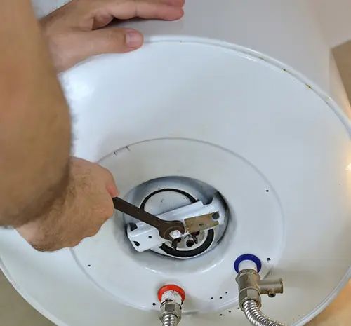 Man Hands Unscrewing a Screw Nut on A Water Heater — Hot Water Maintenance in Crescent Head, NSW