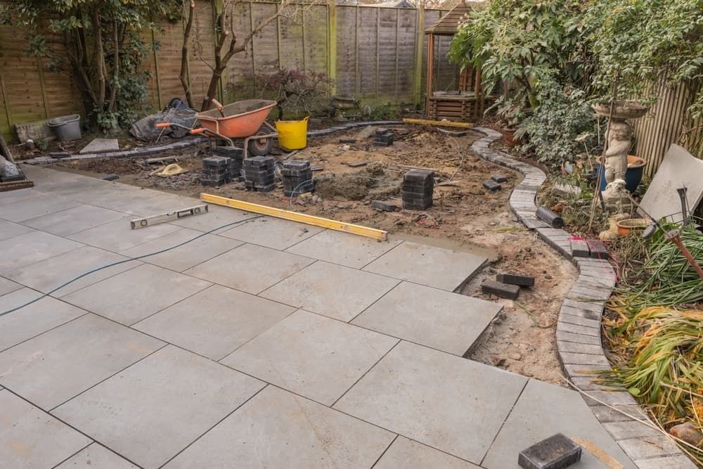 Patio Construction in a Backyard, Featuring Grey Paving Stones — Rhino Excavator & Bobcat Hire in Holloways Beach, QLD