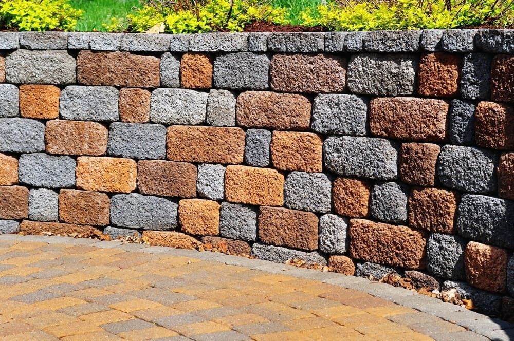 Stone Retaining Wall With Orange, Gray, and Brown Blocks — Rhino Excavator & Bobcat Hire in Trinity Beach, QLD