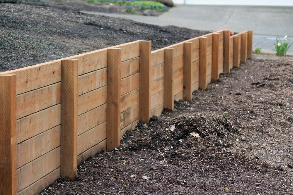 Wooden Retaining Wall on a Sloped Hillside, Brown Wood — Rhino Excavator & Bobcat Hire in Trinity Beach, QLD