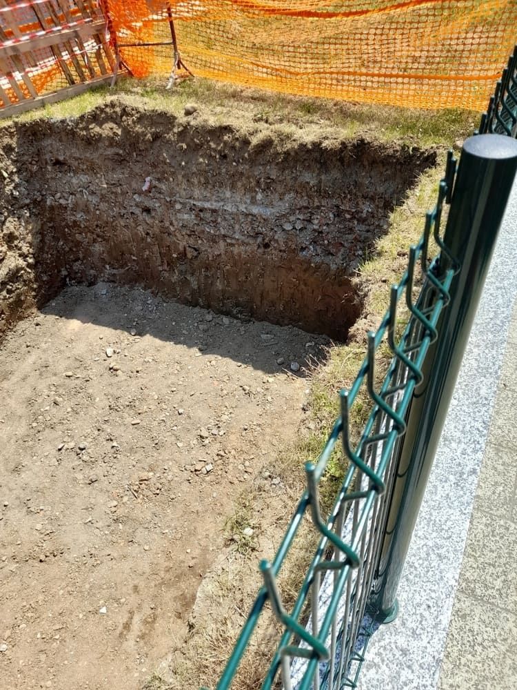 A Square Excavation Pit in the Ground, Bordered by a Green Fence — Rhino Excavator & Bobcat Hire in Trinity Beach, QLD