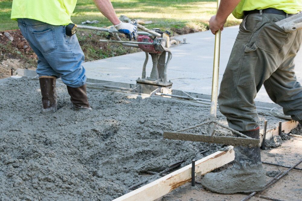 Two Workers Smoothing Wet Concrete With Tools, Outdoors — Rhino Excavator & Bobcat Hire in Gordonvale, QLD