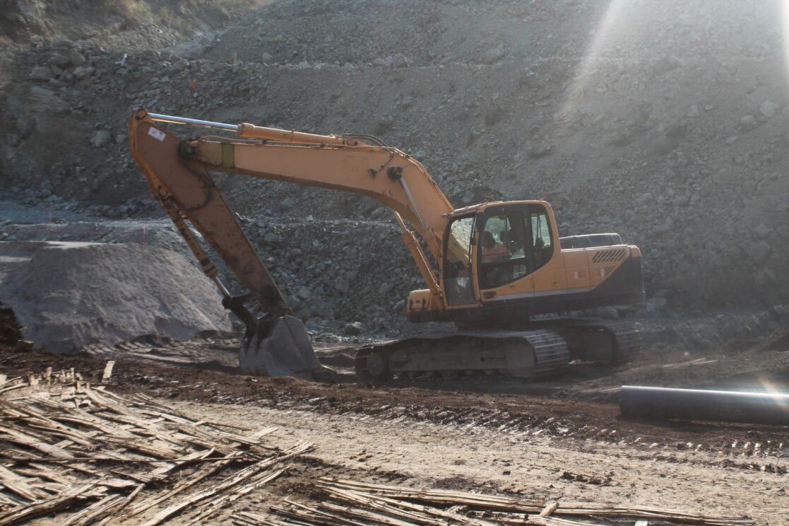 Orange Excavator Digging in a Dirt Pit — Rhino Excavator & Bobcat Hire in Brinsmead, QLD