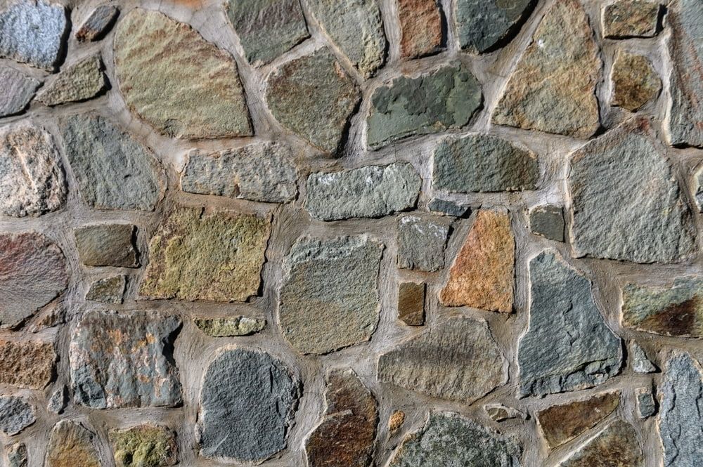 Stone Wall, Various Colors, Irregular Shapes, Gray Mortar — Rhino Excavator & Bobcat Hire in Trinity Beach, QLD