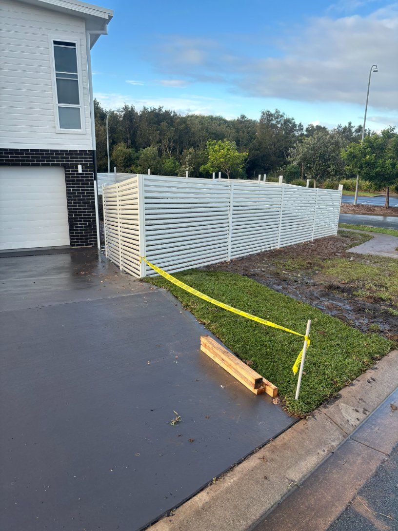 A White Fence Is Being Built in Front of A House — D & B Fencing in Taree, NSW