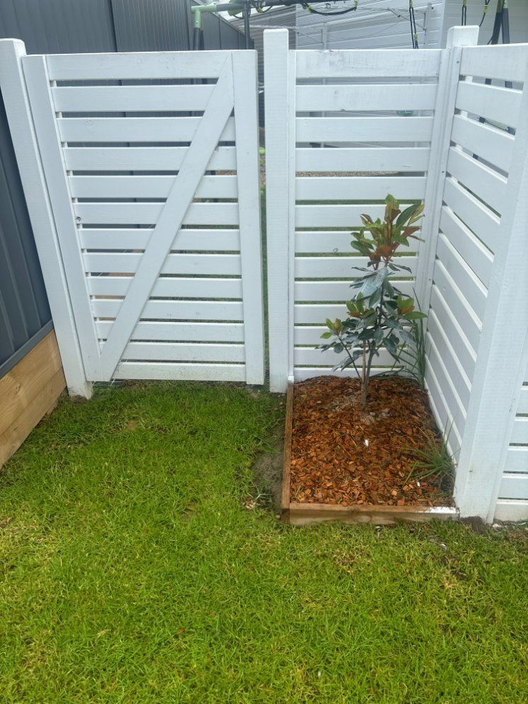 A White Fence with A Small Tree in The Middle of It — D & B Fencing in Taree, NSW