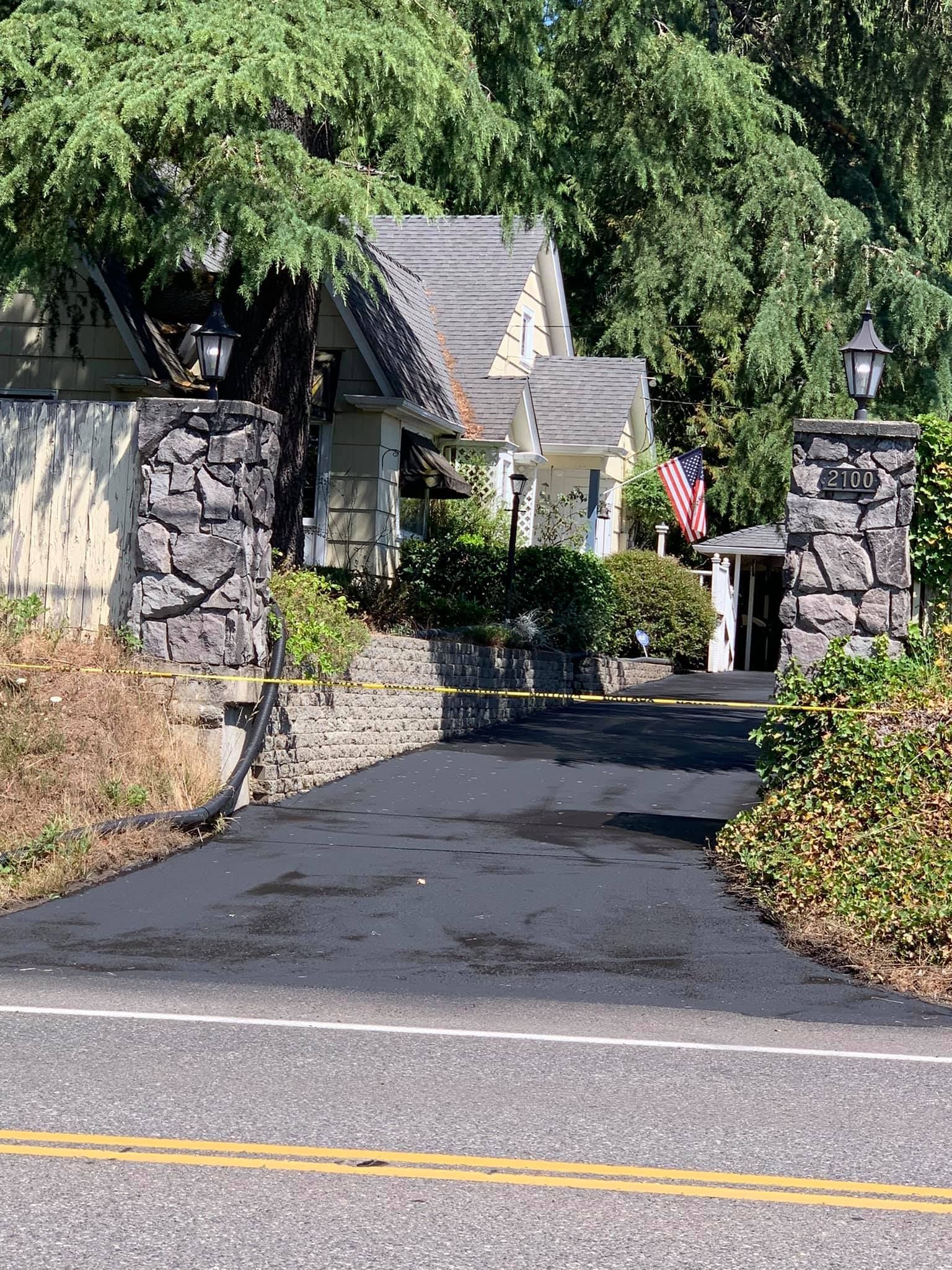 A driveway leading to a house with a flag on the side of it.