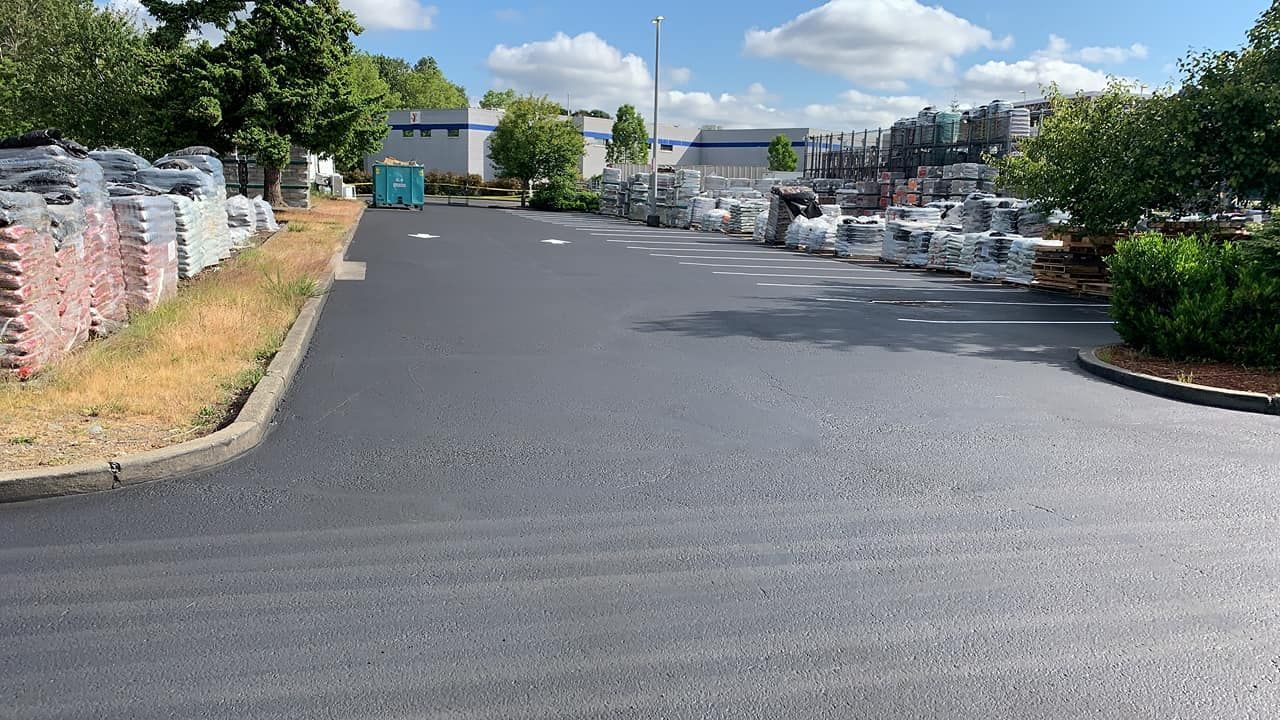 A parking lot with a lot of bags of gravel on the side of the road.