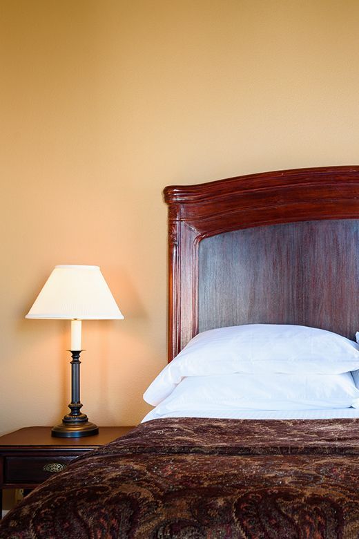 A bed with a lamp next to it in a hotel room
