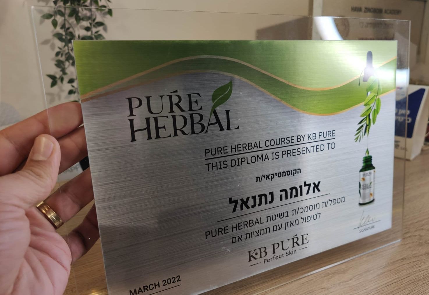 Hand holding a Pure Herbal product box with green and white packaging and Hebrew text