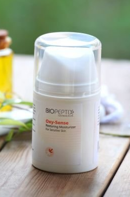 White Biocyte skincare bottle with clear cap on a table, blurred background