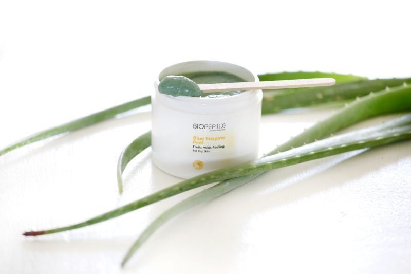 Aloe vera cream jar with green leaves on a white background
