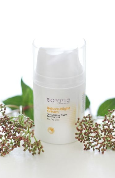Biopetide skincare bottle on a white background with leaves and dried flowers