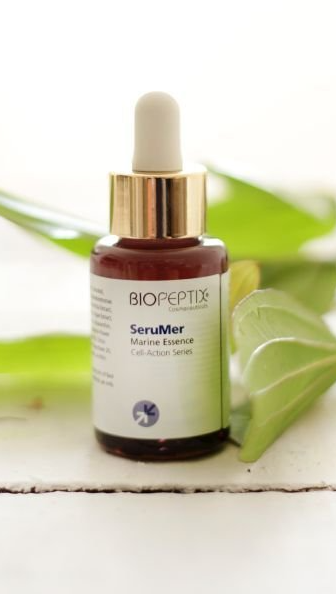 BioPetite SeaWater serum bottle with dropper on a white wooden surface, green leaves in background