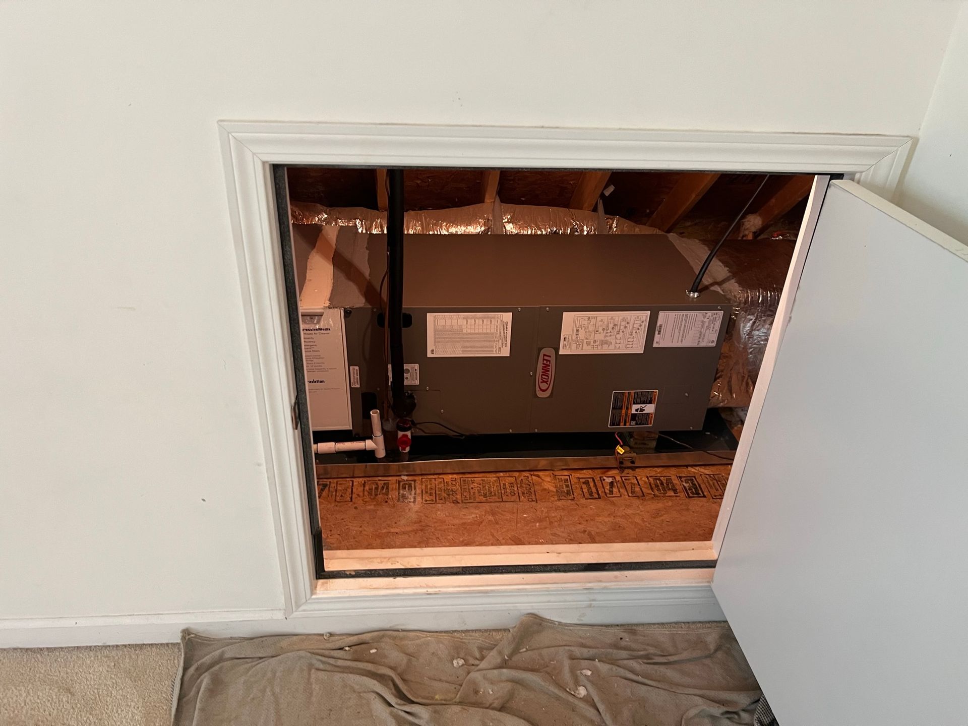 Opening into a utility area reveals an HVAC unit, behind a white door frame.