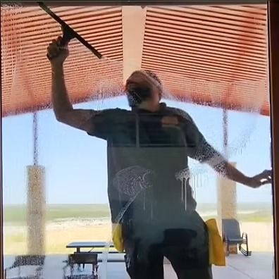 Person holding an umbrella inside a shaded hangar, with aircraft visible outside.