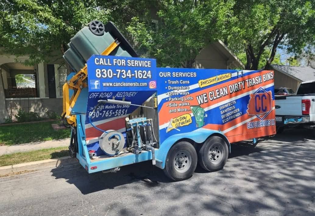Blue and orange plumbing service trailer with contact number parked on a street under trees