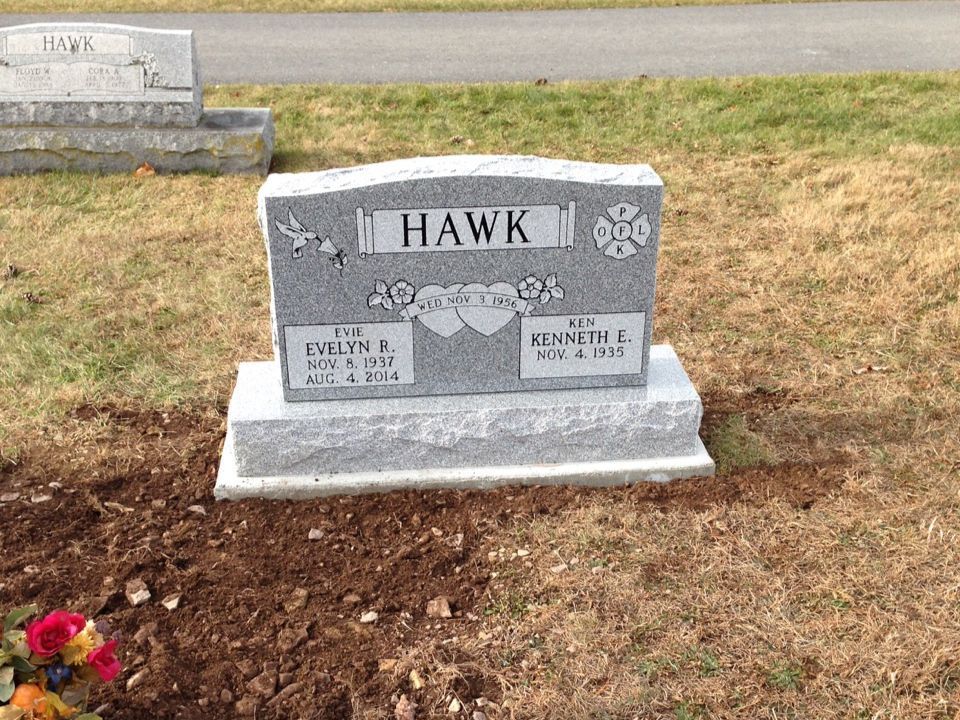 A gravestone in a cemetery with the name hawk on it.