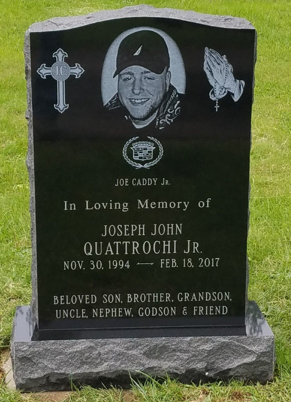 A black gravestone with a picture of a man on it