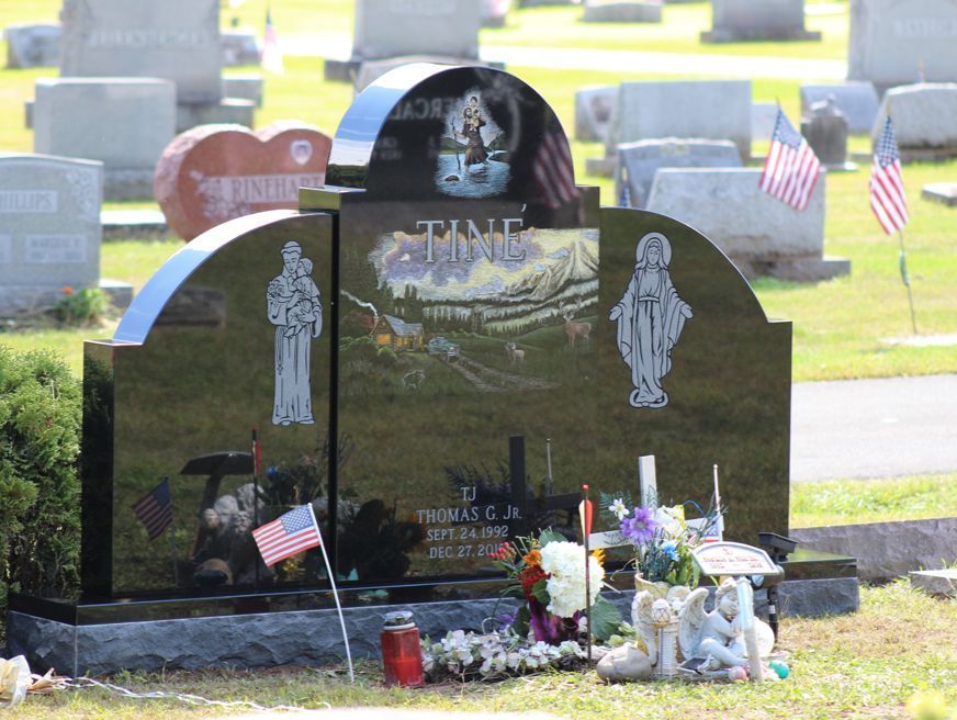 A grave in a cemetery with a statue of jesus on it