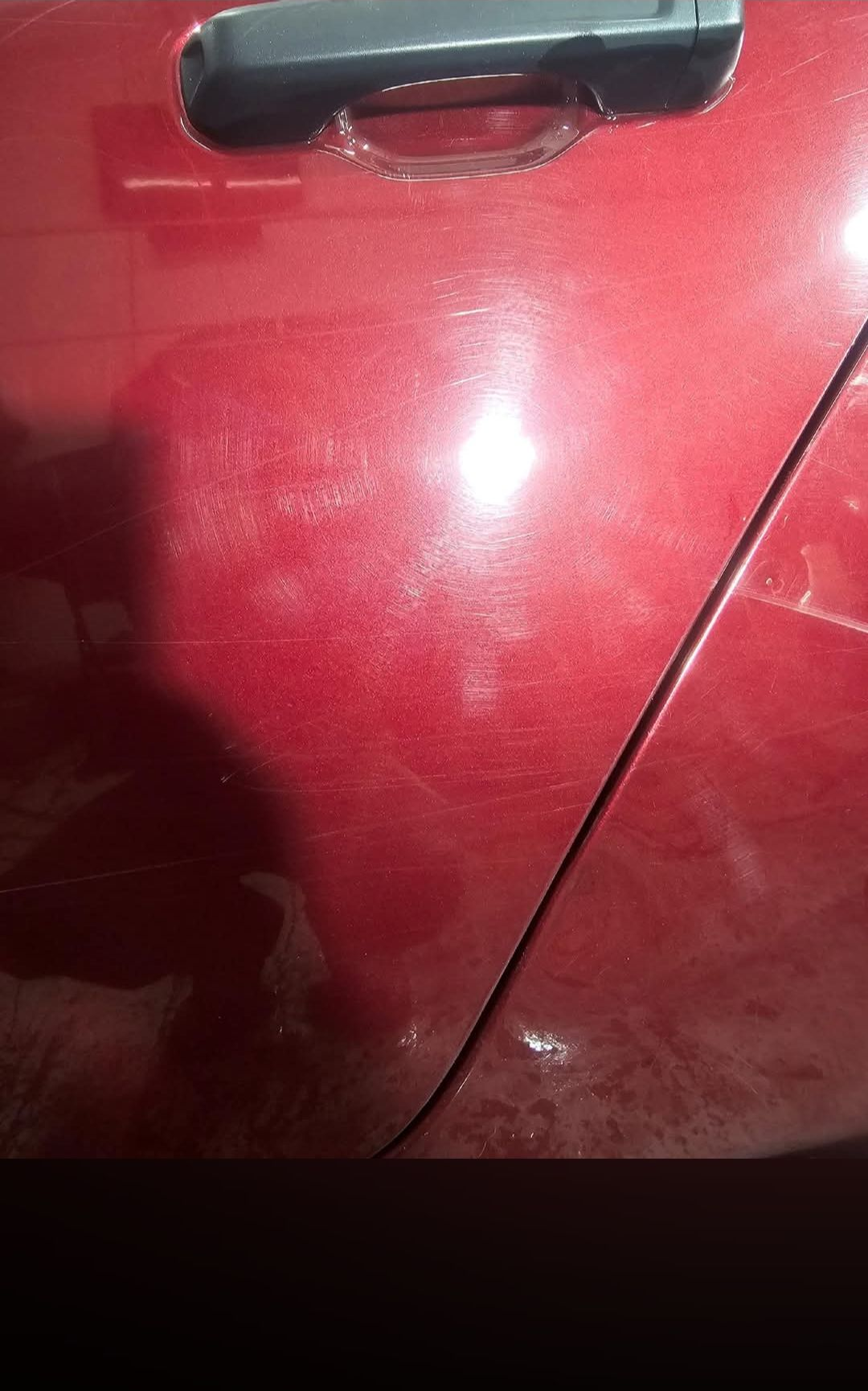 A white SUV showing damage, including dents and paint scuffs, on the rear quarter panel near the tail light.