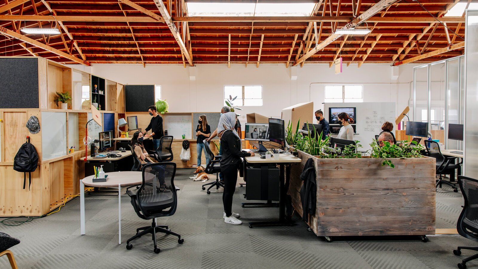 A group of people are working in a large open office.
