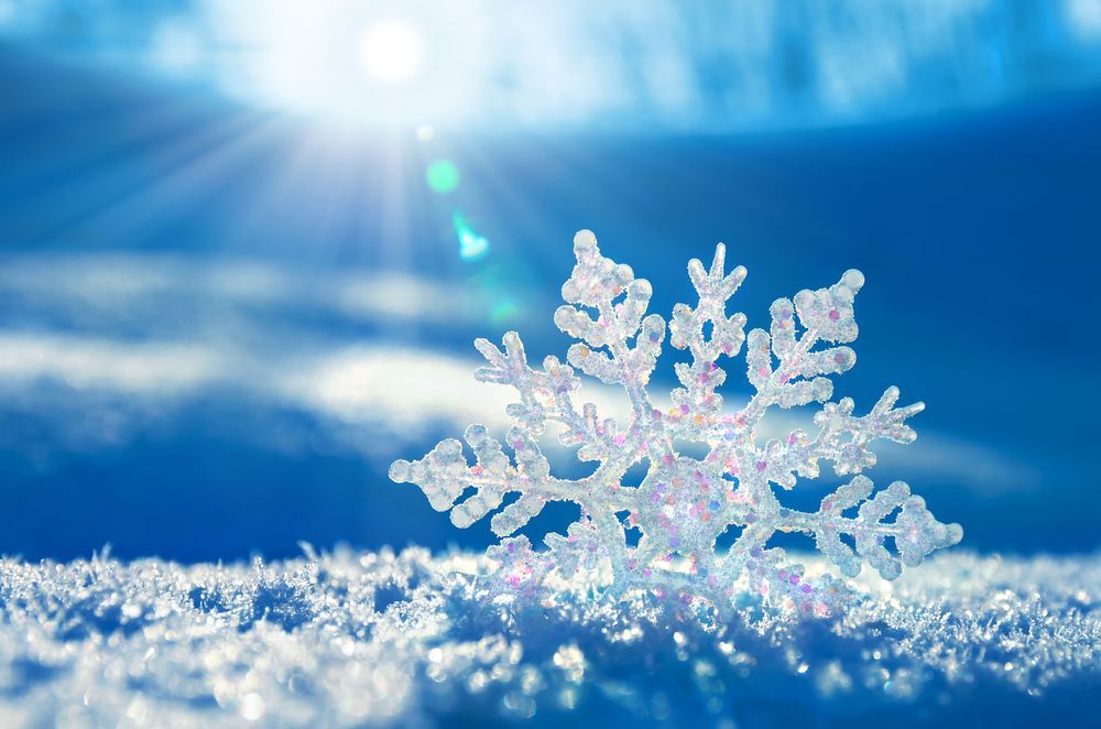A snowflake is sitting on top of a pile of snow.