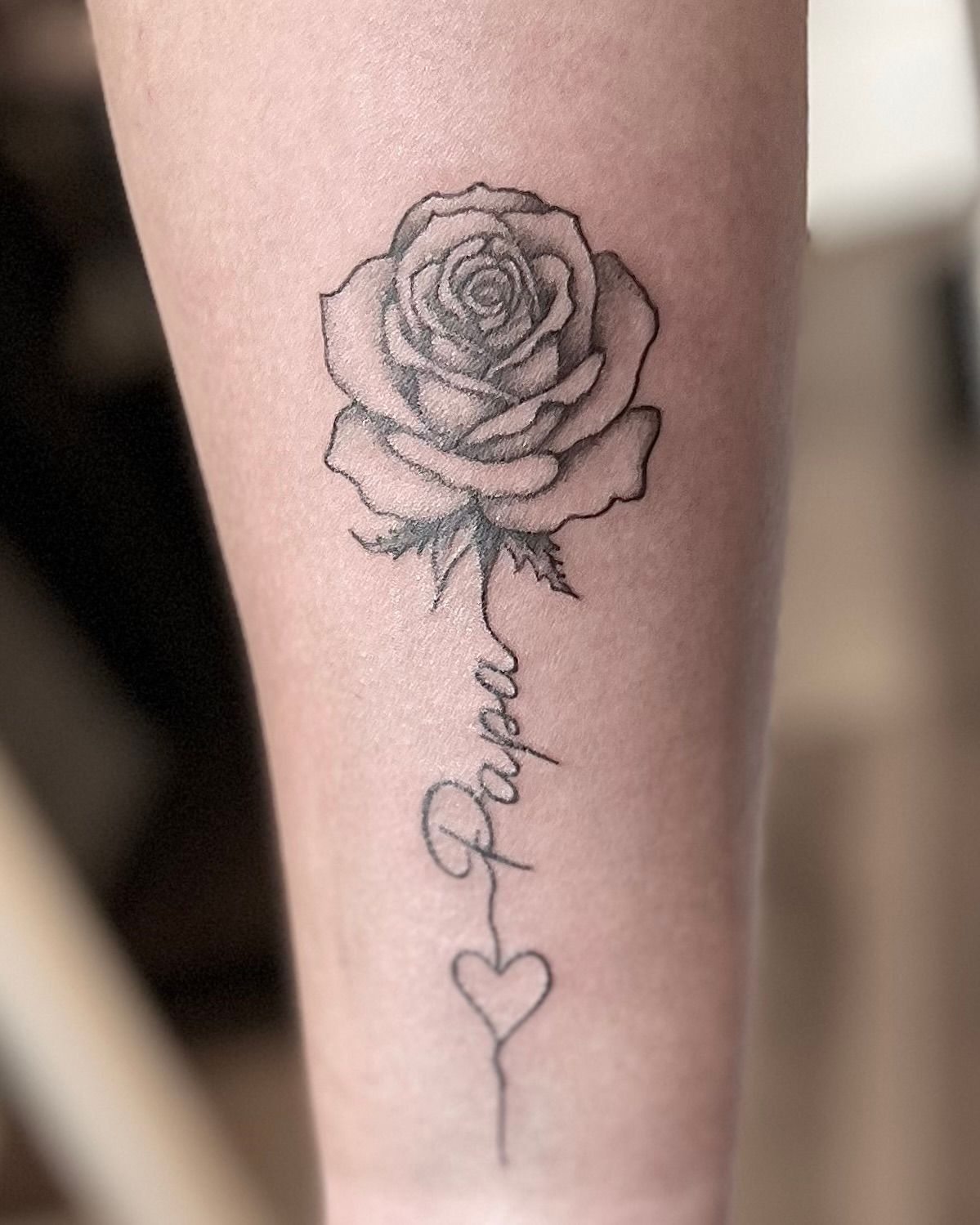 Een roos-tatoeage met het woord 