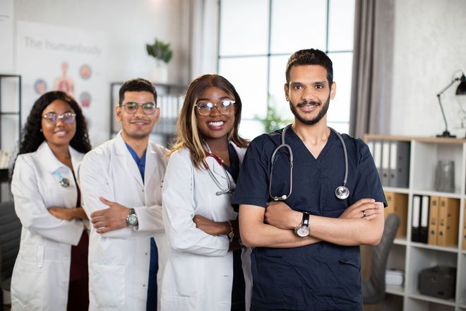 a group of doctors and nurses are posing for a picture in an office .