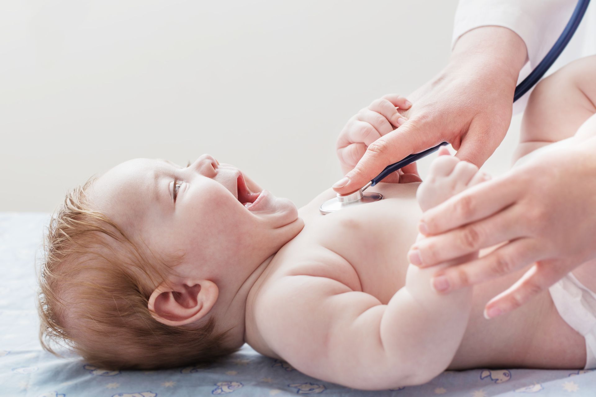 Doctor listens to small child with stethoscope Doctor listens to small child with stethoscope