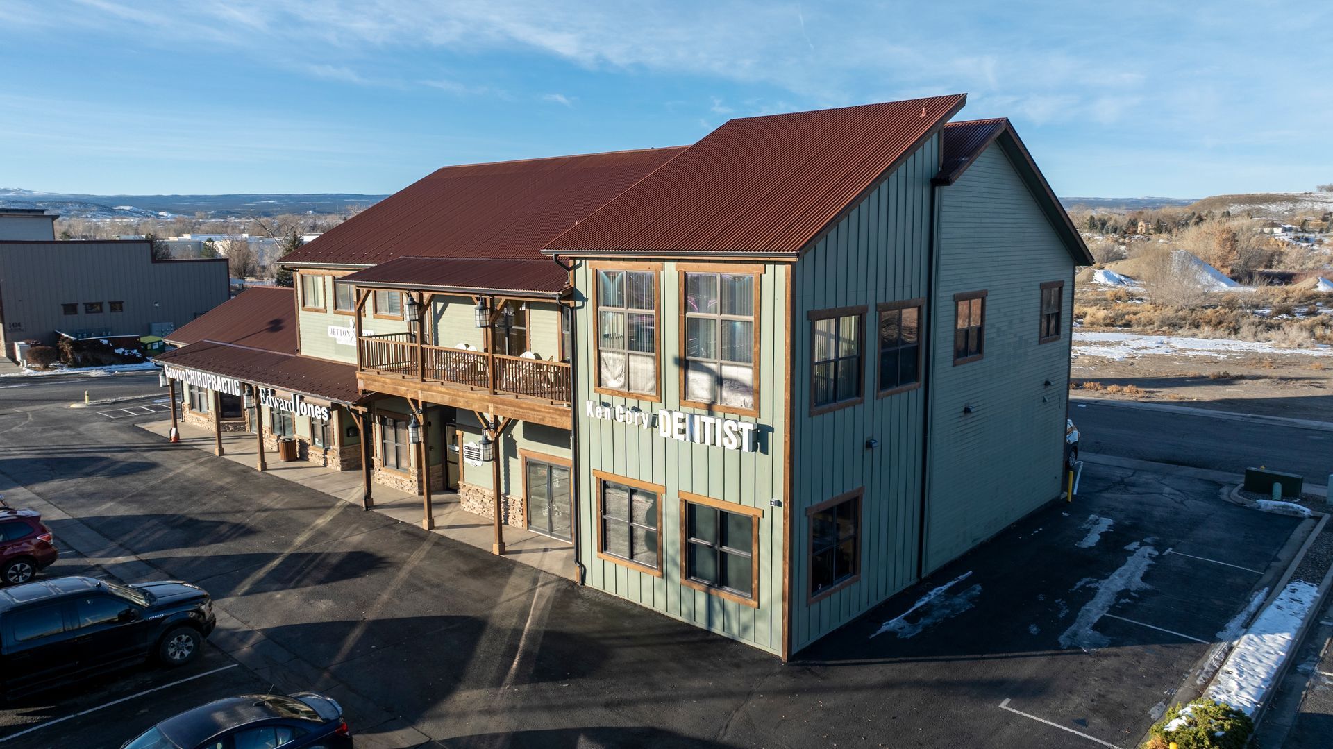 Building with teal siding, large windows, and a sign that says 