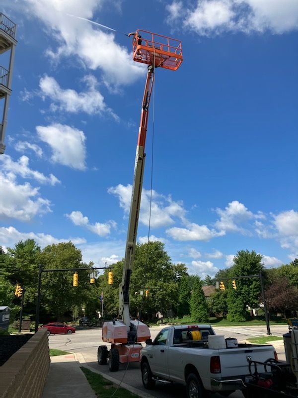 A white truck is parked in front of a crane.