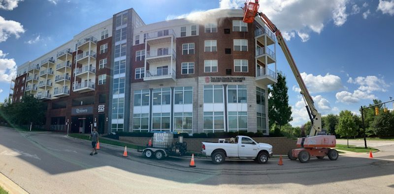 A white truck is parked in front of a large building.