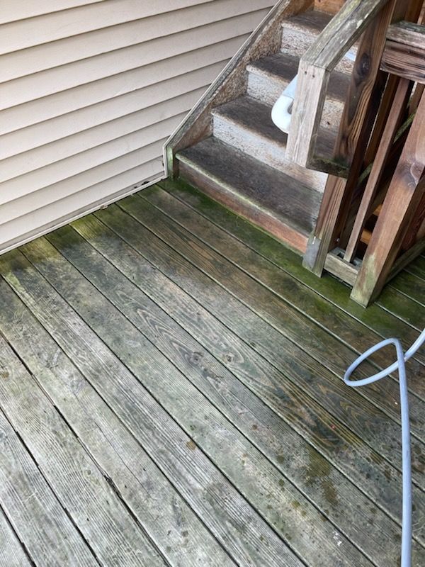 A wooden deck with stairs and a hose on it.