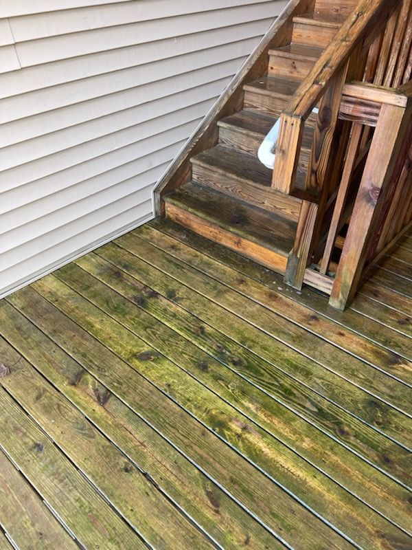 A wooden deck with stairs leading up to a house.