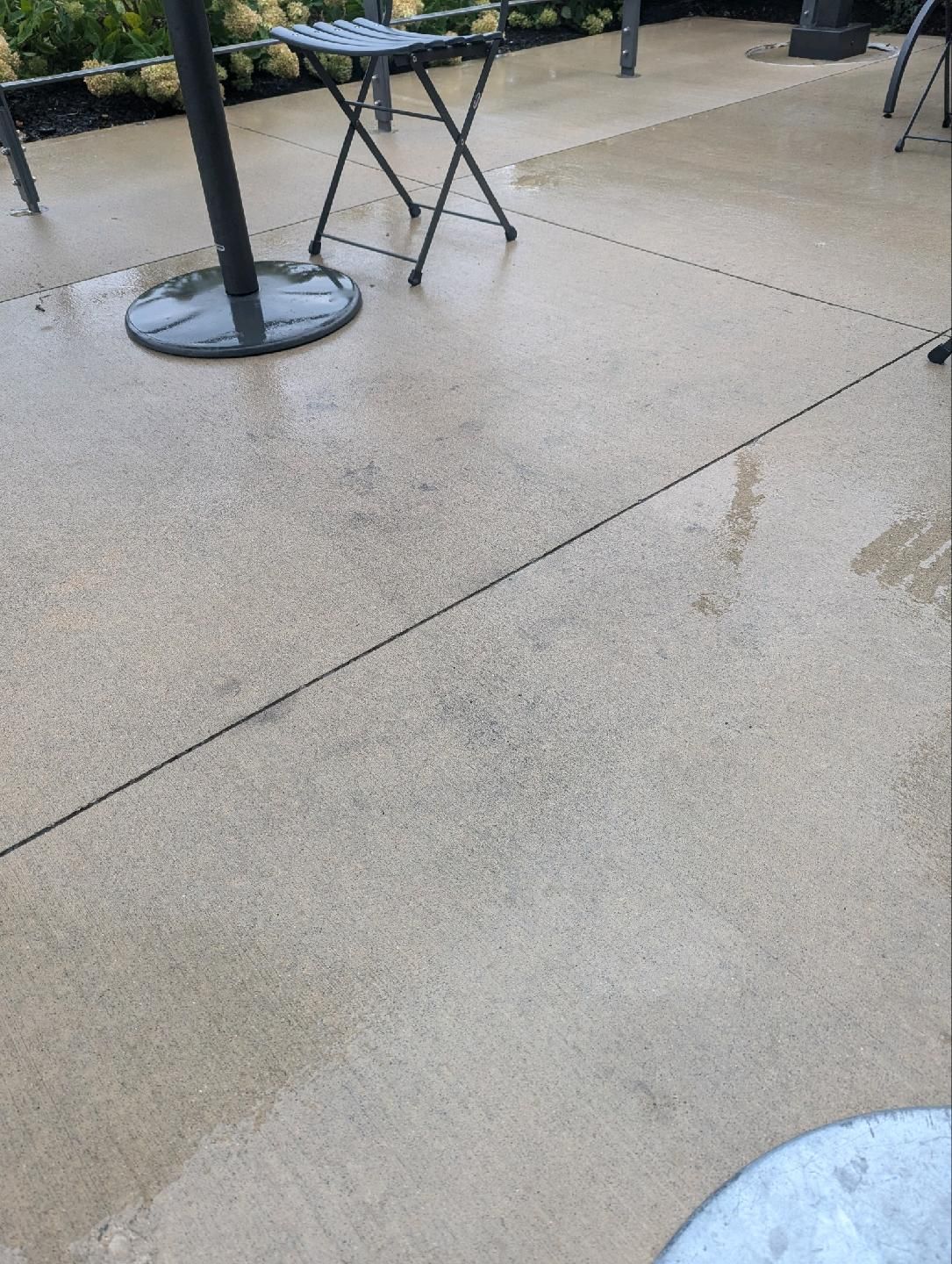 A concrete patio with a table and chairs on it.