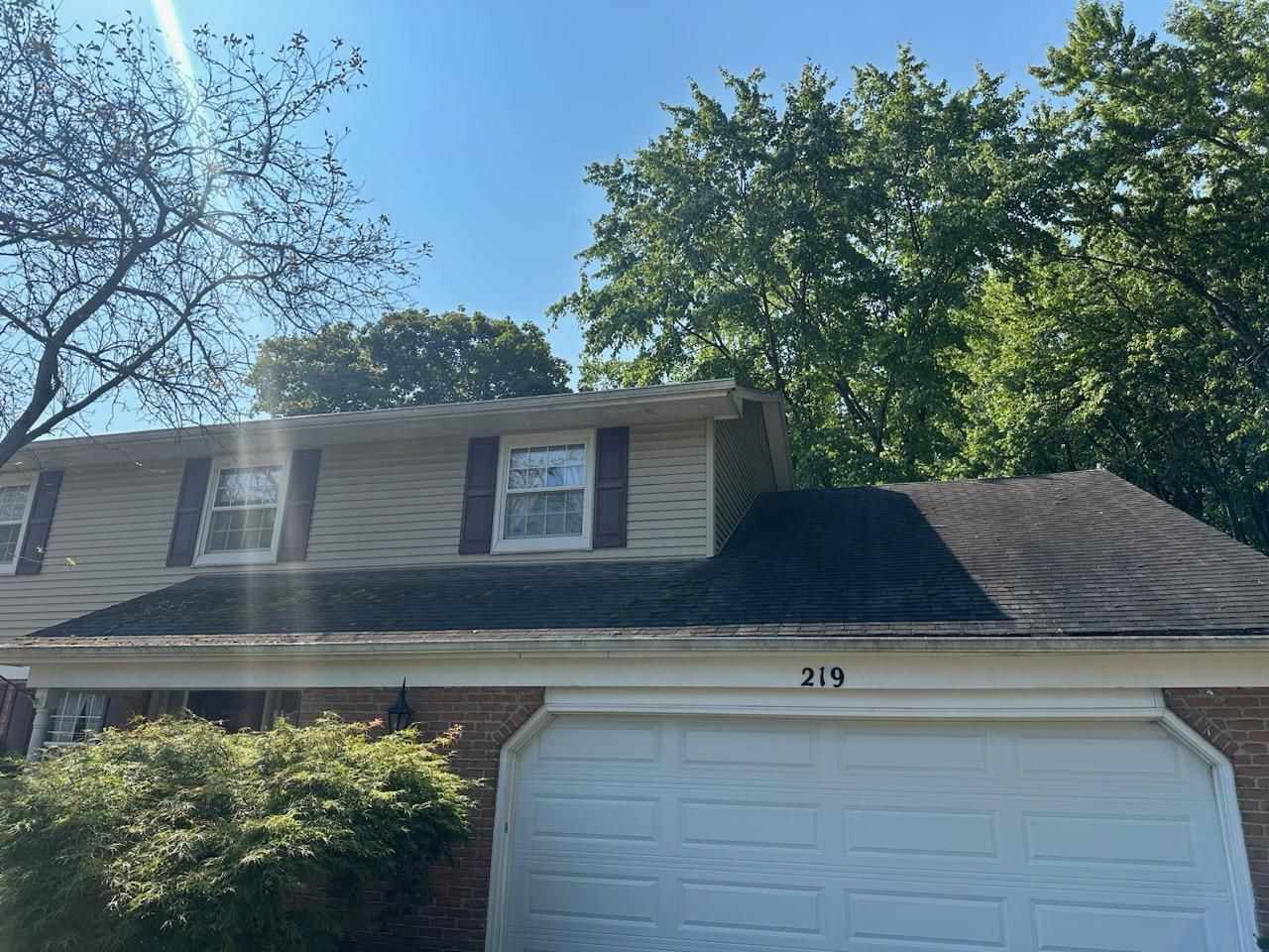A house with a black roof and a white garage door