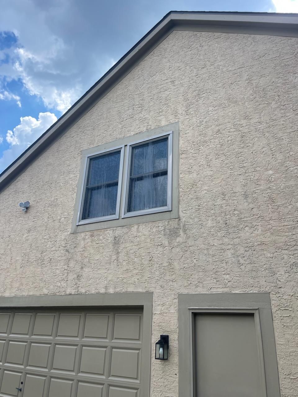 A house with two windows and a garage door