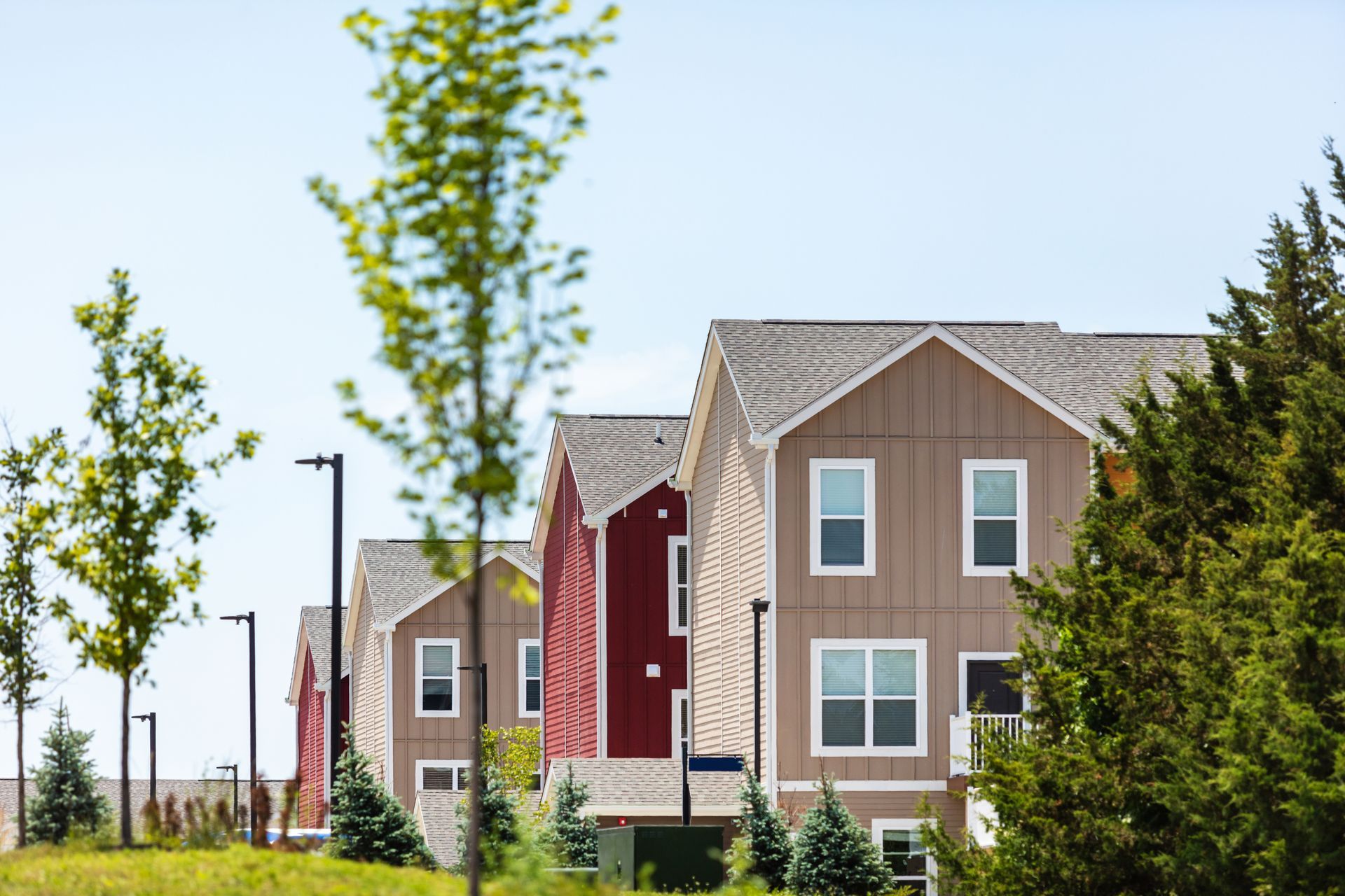 A row of apartment buildings with trees in front of them.