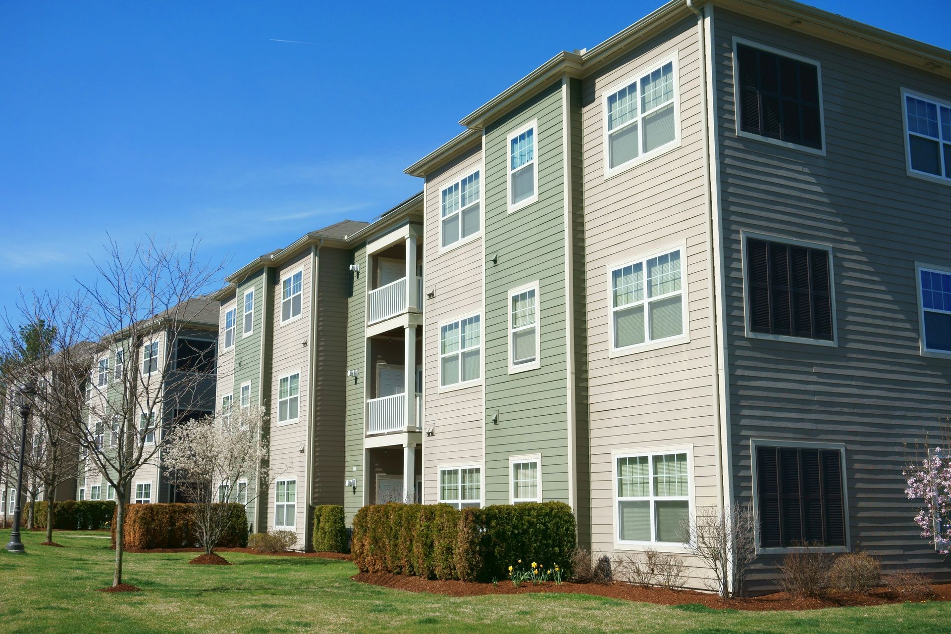 A large apartment building with lots of windows on a sunny day