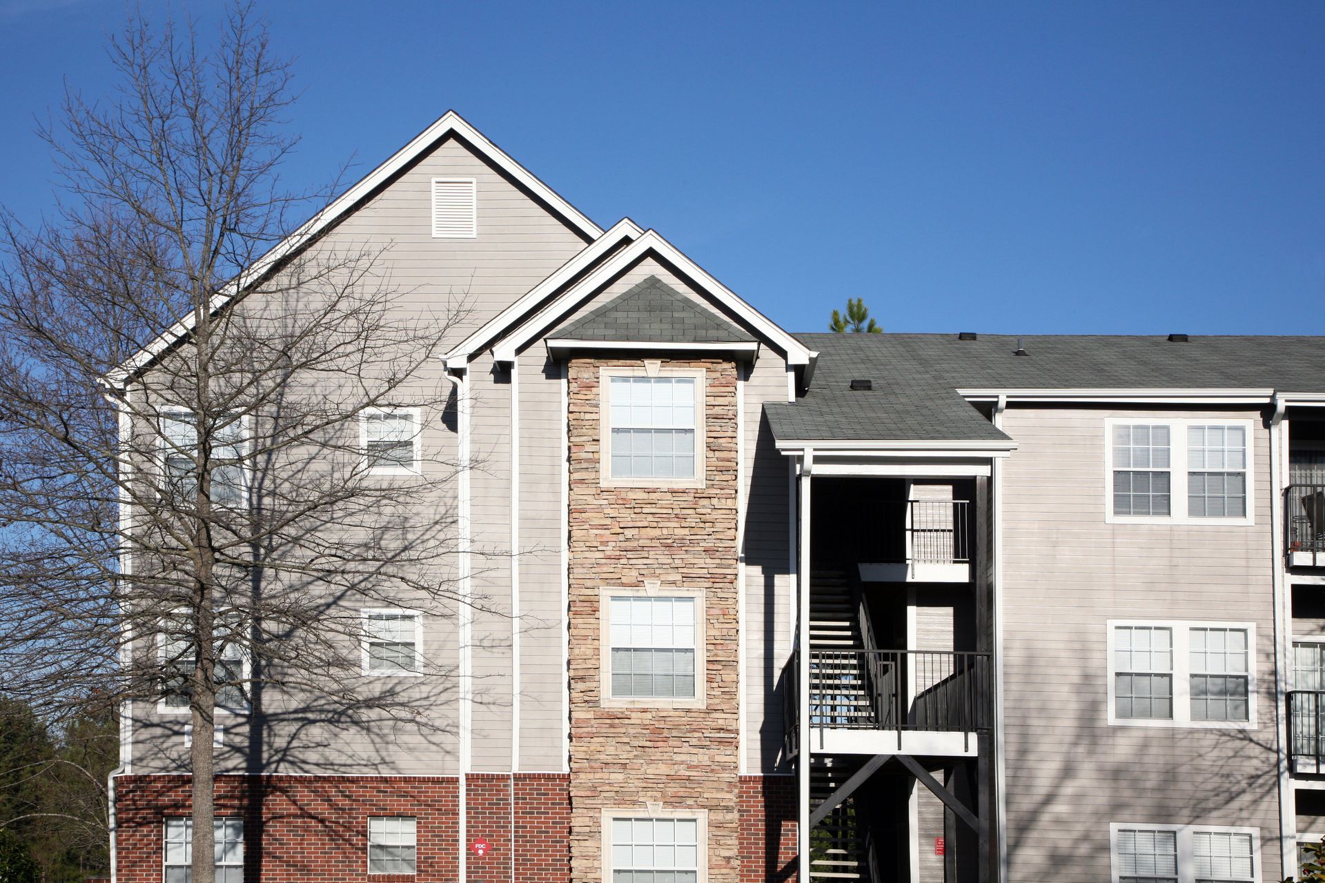 A large apartment building with a blue sky in the background