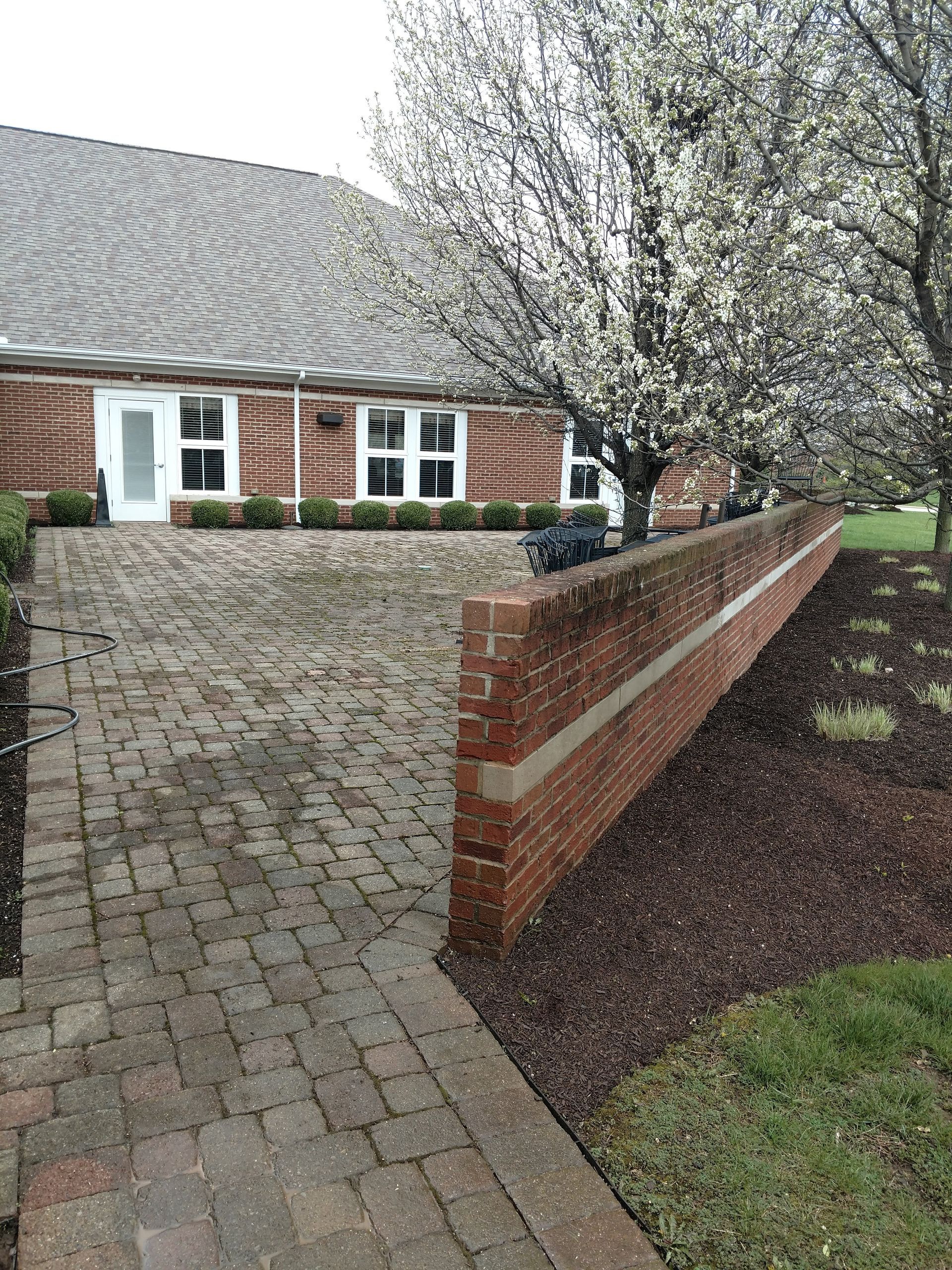 A brick walkway leading to a brick house