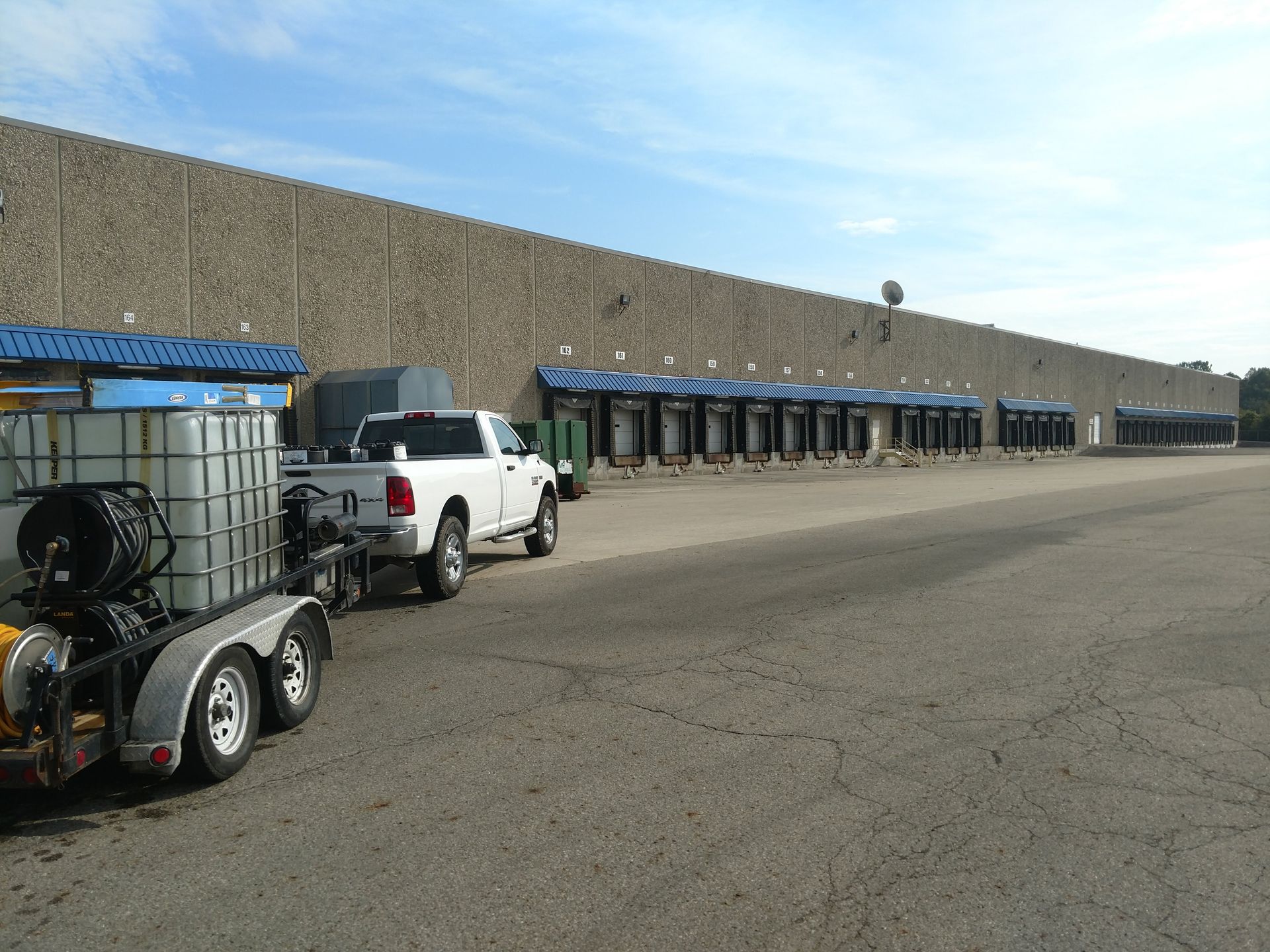 Two trucks are parked in front of a large building