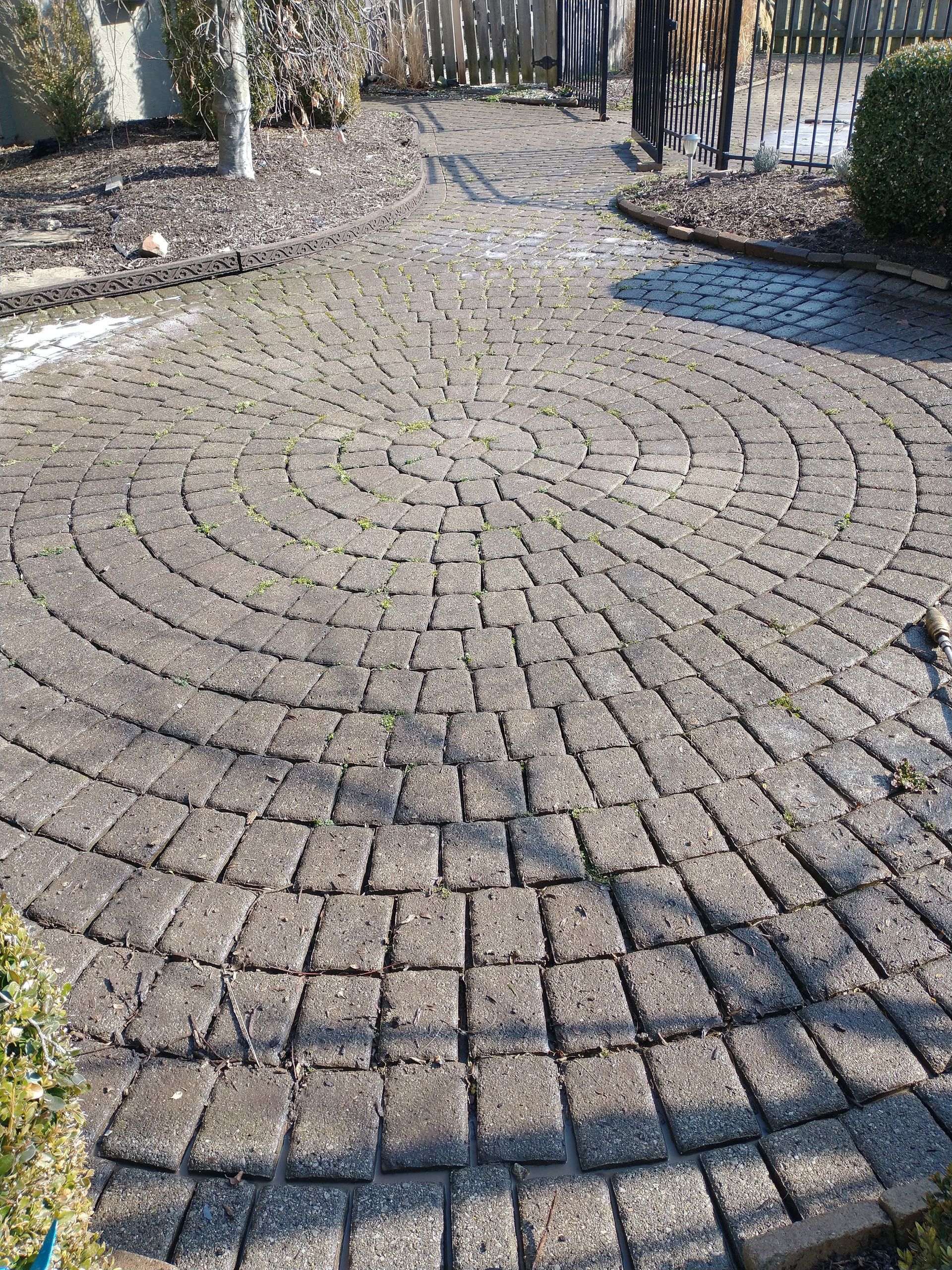 A brick walkway with a labyrinth in the middle of it.