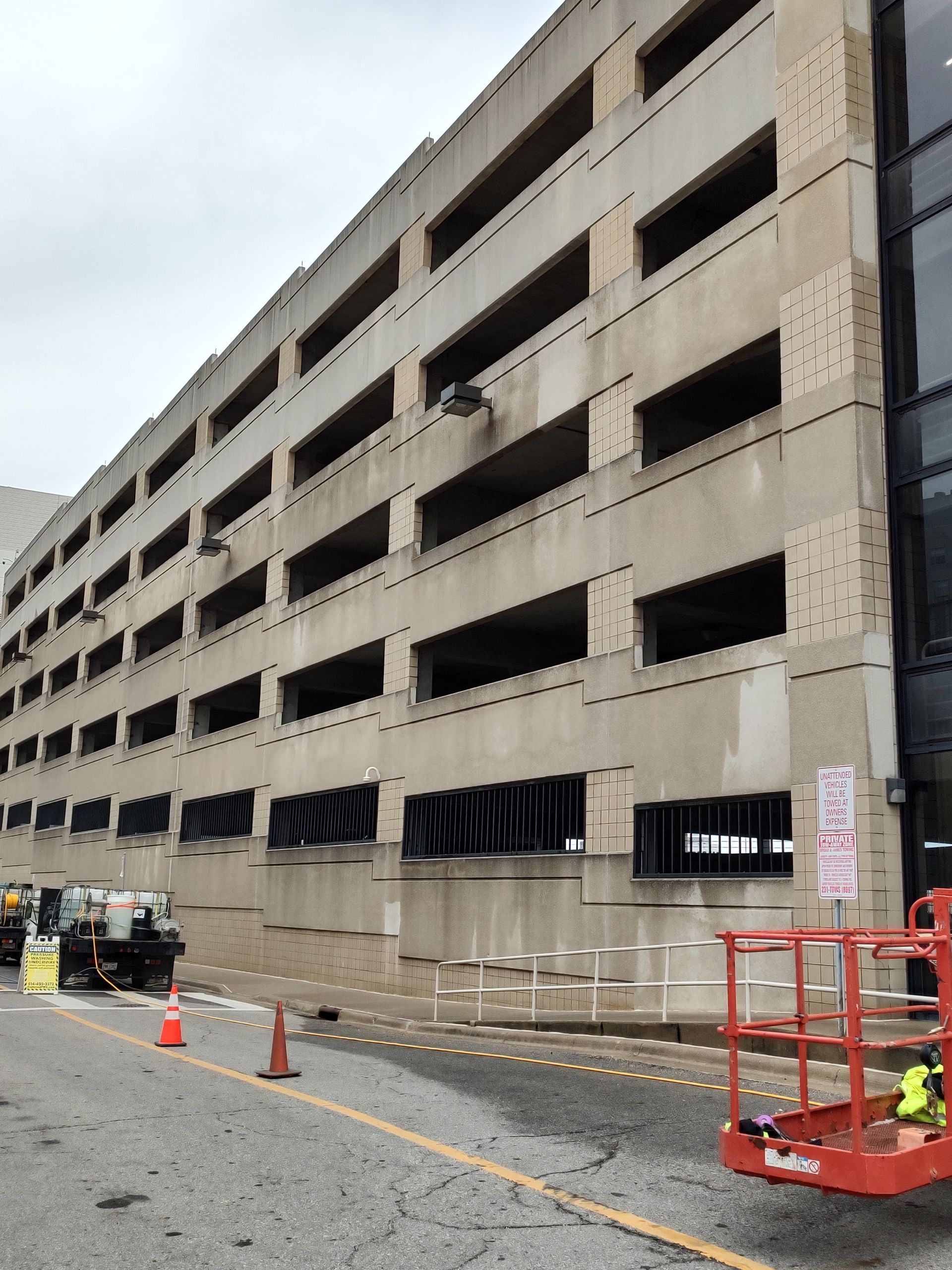 A construction vehicle is parked in front of a large building.