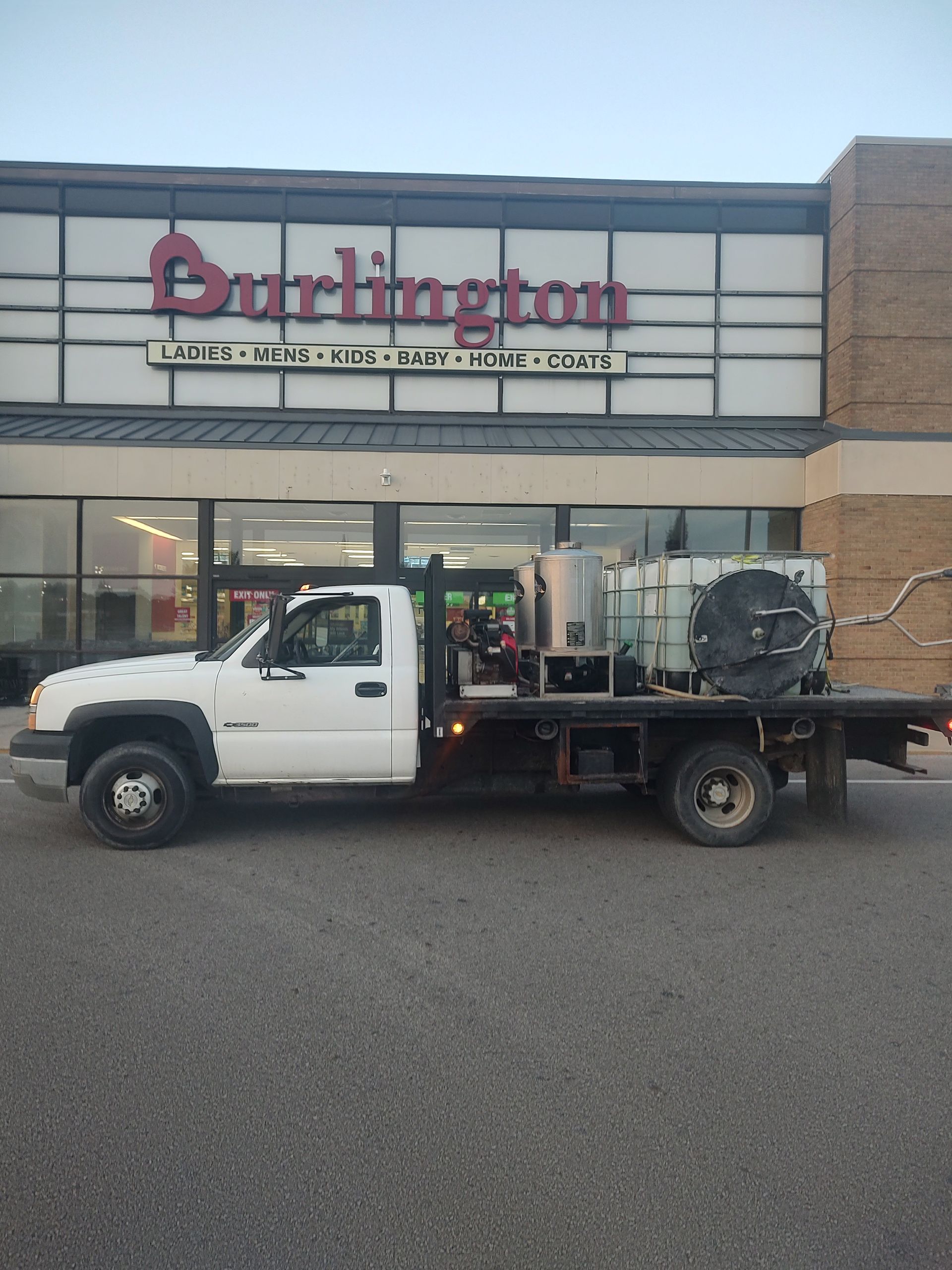 A white truck is parked in front of a burlington store