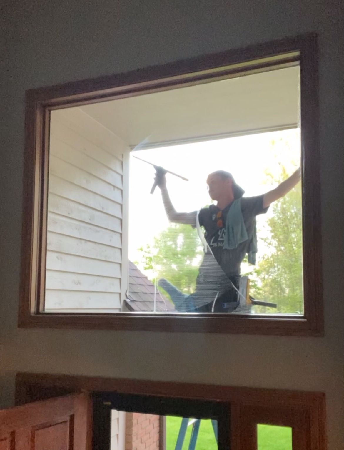 A man is cleaning a window with a squeegee